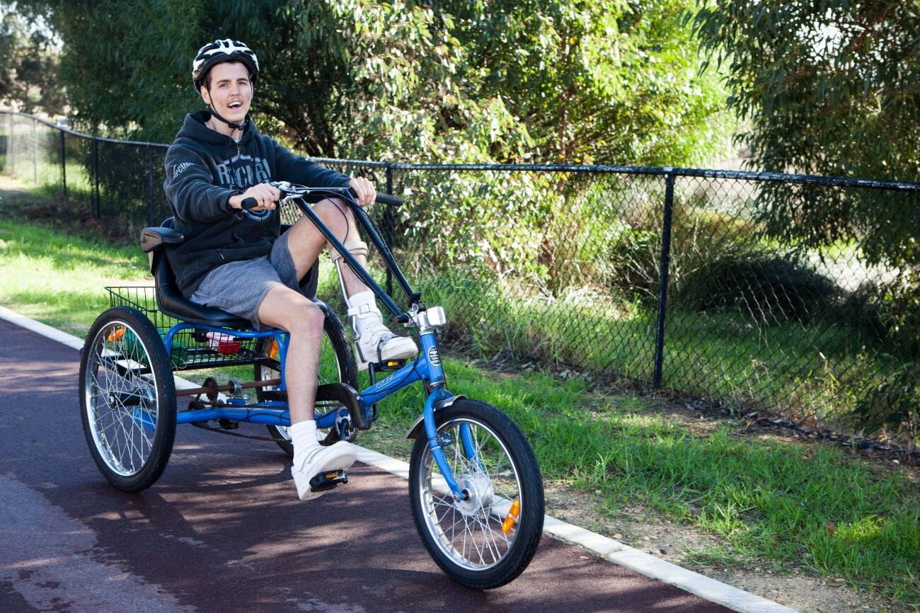 Man with brain injury riding a three wheeler bike